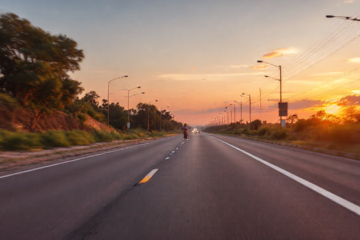 Motorista de caminhão realizando entrega em uma estrada.